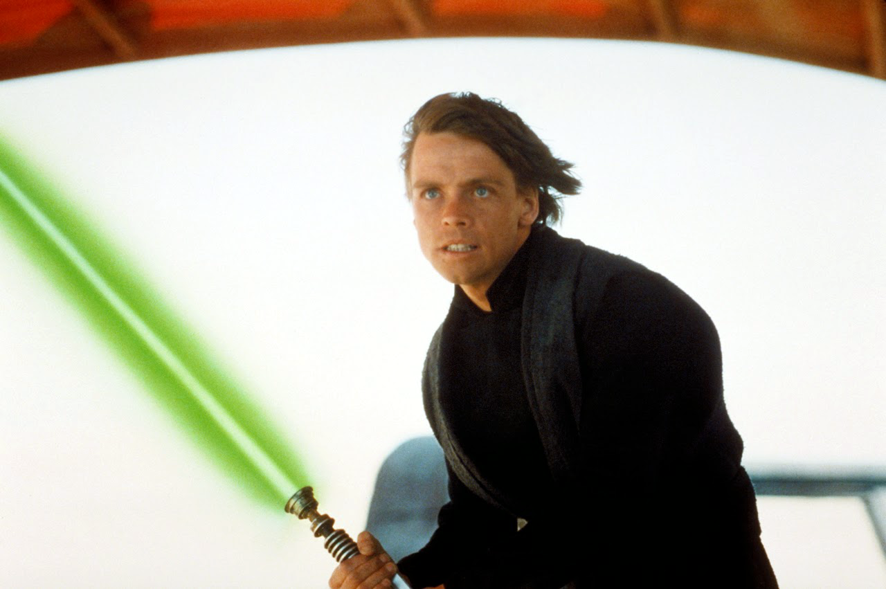An image of a young Luke Skywalker wielding his green lightsaber